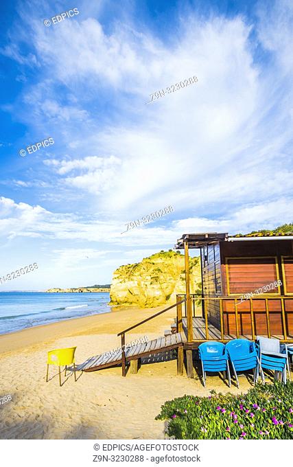 wooden beach hut and chairs on deserted beach in pre-season, praia da rocha, portimao, algarve, portugal