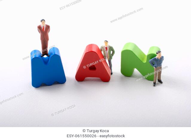 Tiny figurine of men beside colorful wooden letters say MAN