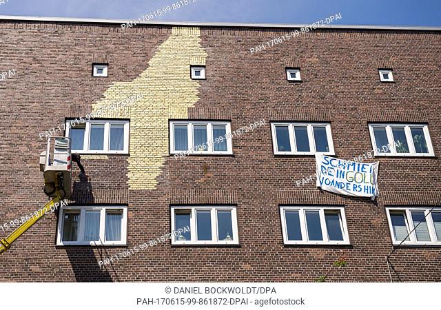 The artist Boran Burchhardt photographs blue colour patches on the house facade in the district Veddel, Hamburg, Germany, 15 June 2017