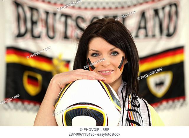 Female German soccer supporter stood holding ball