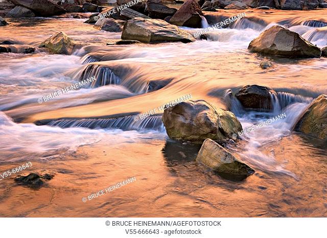 Autumn colors reflecting in tumbling waterfalls in Virgin River in Zion National Park, Utah, USA