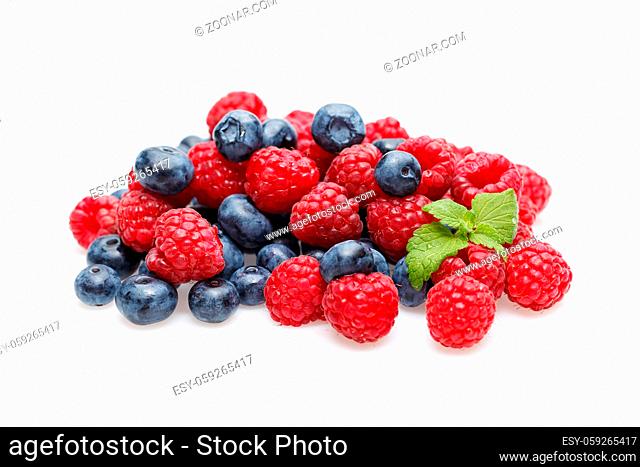 natural blueberry and raspberry berries with mint leaves isolated on white background. copy space