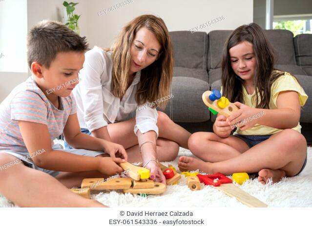 Single mother playing with her kids at home. High quality photography