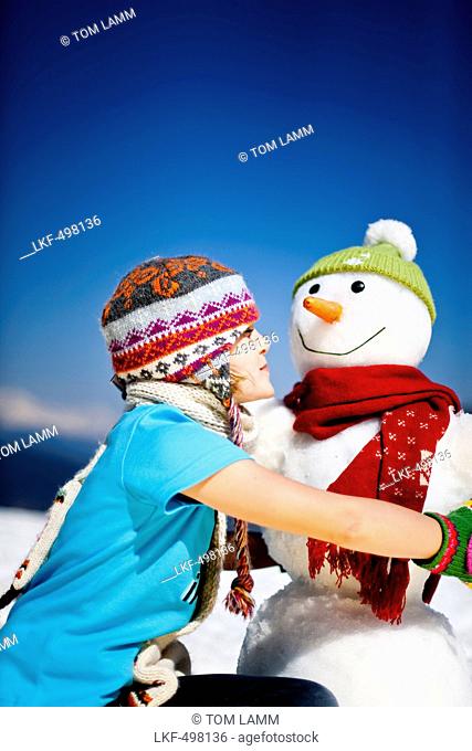 Girl and a snowman, Frauenalpe, Murau, Styria, Austria