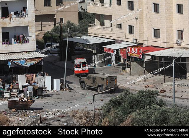 19 June 2023, Palau, Jenin: An ambulance of the Palestine Red Crescent drives amid clashes between Israeli forces and Palestinians during a large-scale Israeli...
