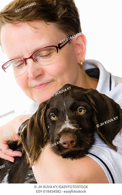 Happy woman and German wirehaired pointer puppy, 12 weeks old, white background, vertical format