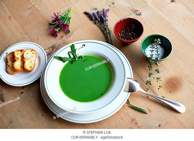 Table with fresh green soup and bread