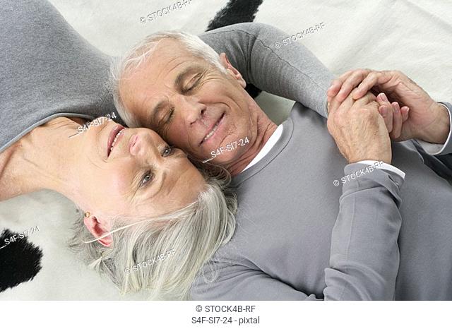 Senior couple lying head to head