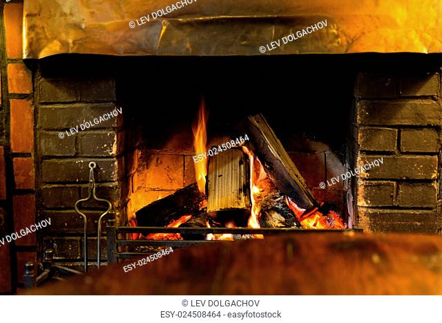 stove heating and fire concept - close up of burning fireplace at home