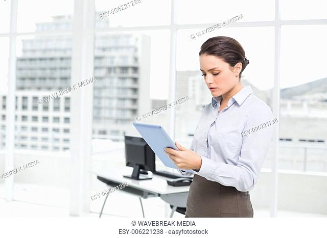 Serious businesswoman using table PC in office