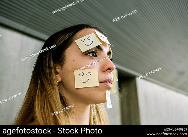Portrait of serious woman wearing adhesive notes on face