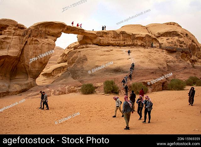 Wadi Rum, Jordan, March 2020: People, tourists, climbing the Um Frouth natural Rock Bridge