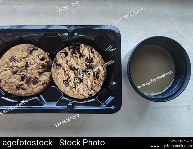 Chocolate chip cookies in the package and vacuum flask coffee cup. Coffee at work concept