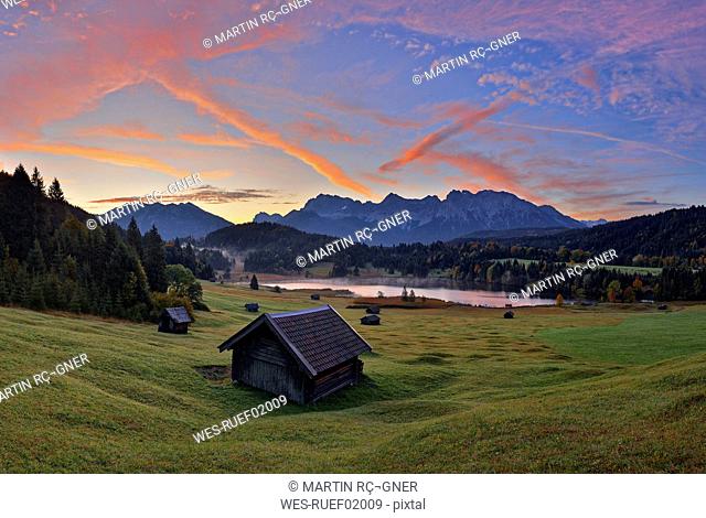 Germany, Bavaria, Werdenfelser Land, lake Geroldsee with hay barn at sunset, in background the Karwendel mountains at sunrise