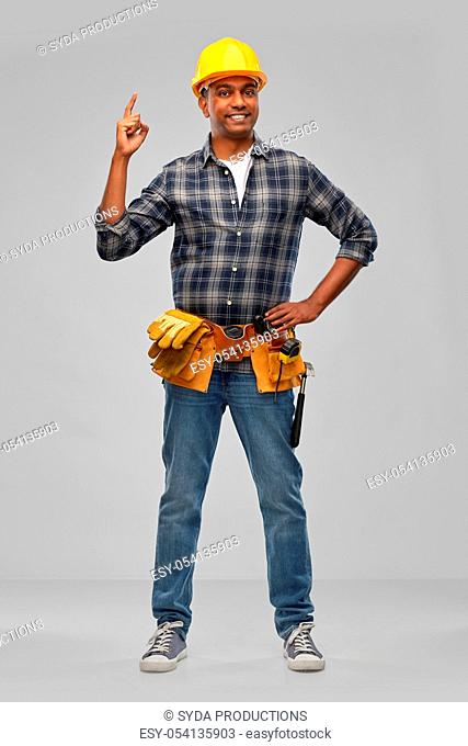 happy indian builder in helmet with tool belt