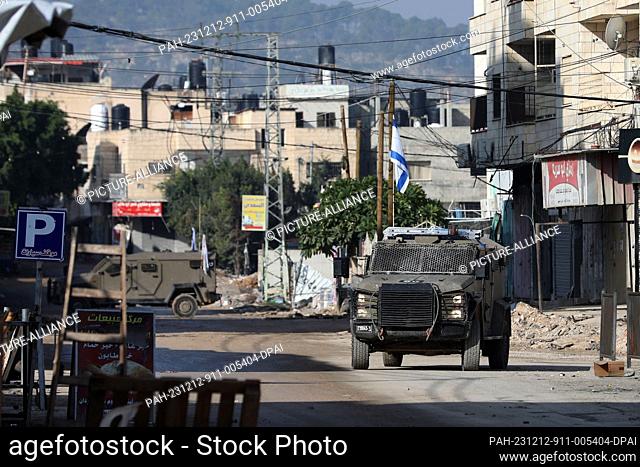 12 December 2023, Palestinian Territories, Jenin: An Israeli military vehicle parks during a raid at the Jenin refugee camp in the occupied West Bank