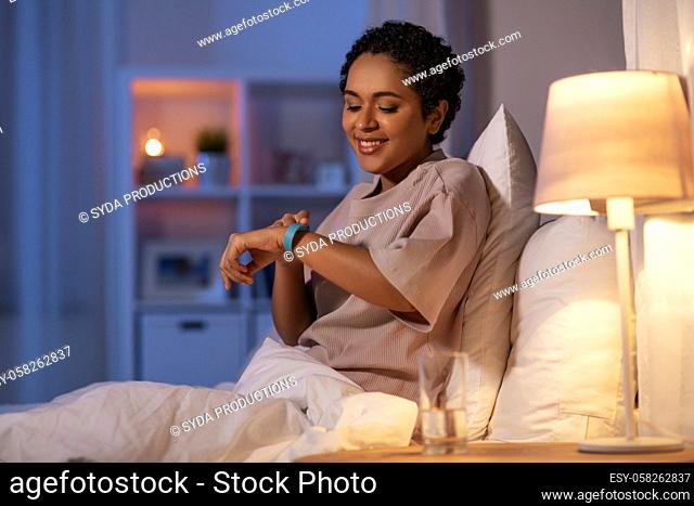 woman with health tracker in bed at night