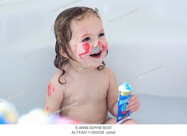 Little girl playing in bathtub