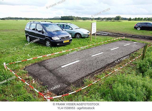 Example of cycle path in meadow temporary used as parking place for cars. The Netherlands