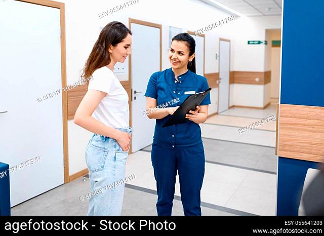 Female surgeon talks with patient in clinic hall, surgery. Doctor in uniform, medical worker, medicine and health, professional healthcare in hospital
