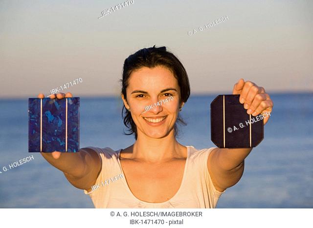 Woman holding a solar panel towards the sun