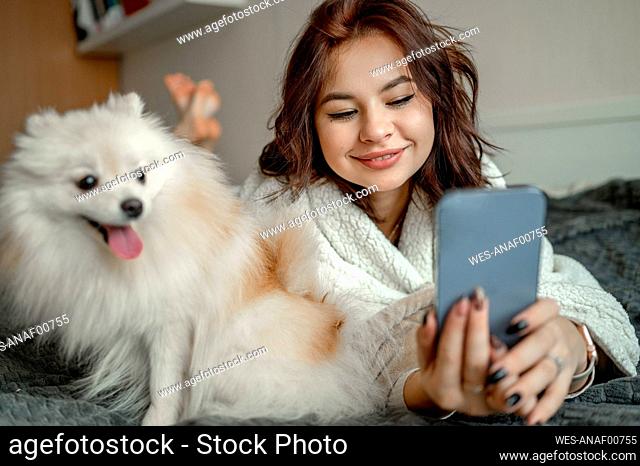 Happy woman using smart phone at home