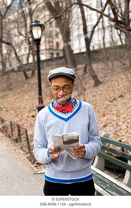 Man reading a newspaper in a park, Central Park, Manhattan, New York City, New York State, USA