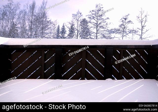 Beautiful winter scenery from a german house balcony with wooden railing, all covered with fluffy snow
