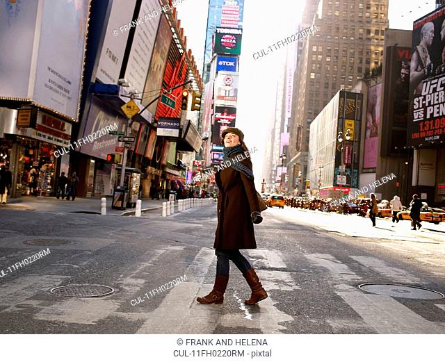 Woman crossing road in Times Square