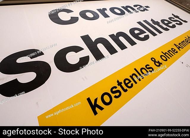 01 September 2021, Bavaria, Munich: A sign with the inscription ""Corona quick test - free of charge and without registration"" is stuck on a converted shop in...