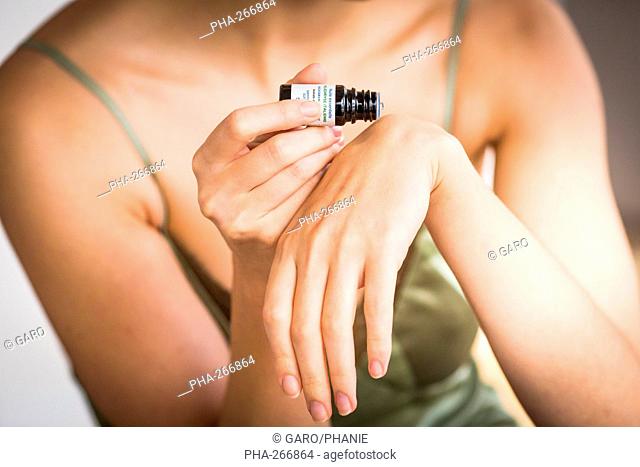 Woman applying essential oil on her skin