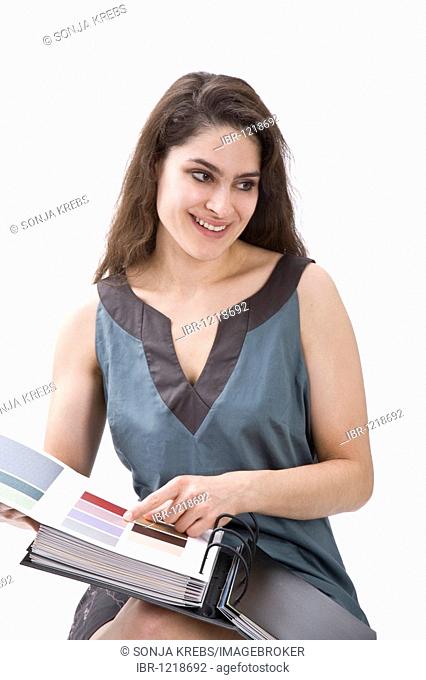 Girl pointing at colour sample in a catalogue