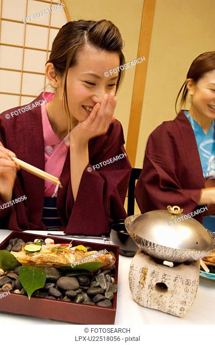 Women in yukatas eating seafood