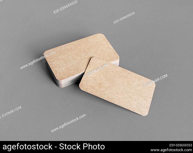 Mockup of blank kraft business cards on gray paper background