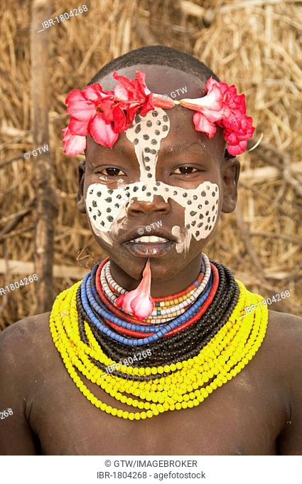 Karo girl with a floral headband, facial paintings, colorful necklaces and lip piercing, Omo river valley, Southern Ethiopia, Africa
