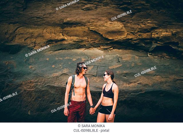 Couple posing against rock face, Canoa, Manabi, Ecuador