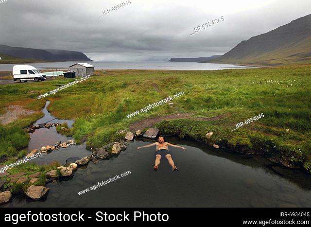Natural pool at fjord, hot pot, geothermal spring, man bathing Reykjafjarðarlaug, Vestfirðir, Westfjords, Iceland, Europe