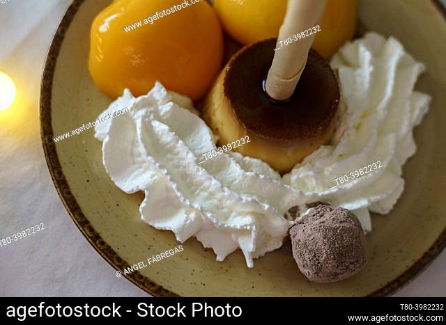 Christmas dessert of egg flan with whipped cream, truffle, peach in syrup and neula