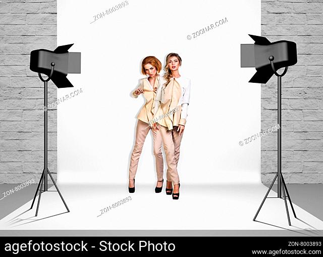 Models in photo studio room with white cloth and spotlights