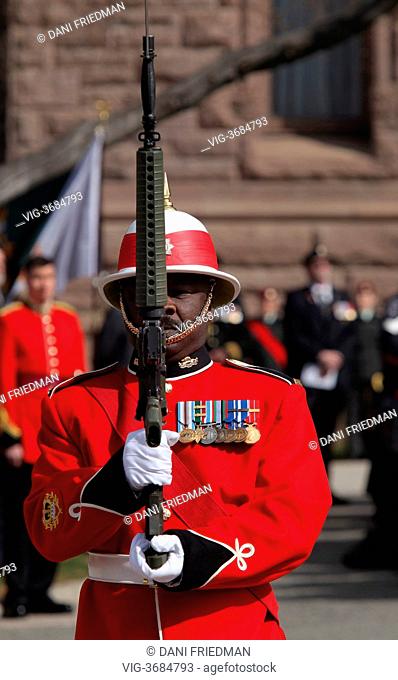 CANADA, TORONTO, 27.04.2013, A member of the 3rd Battalion of the Royal Canadian Regiment presents arms during the presentation of a new Regimental Colour by...