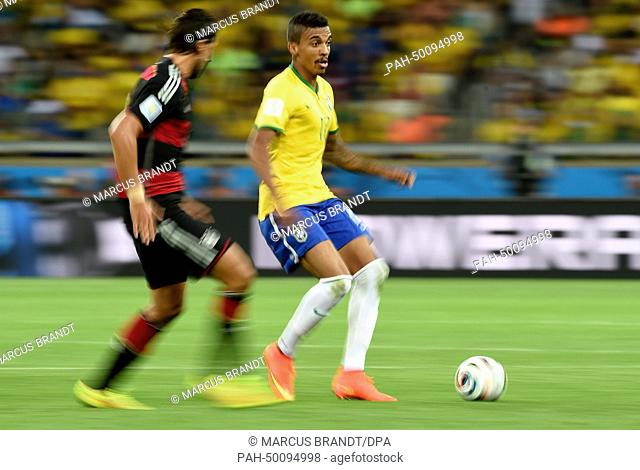 Sami Khedira (L) of Germany and Luiz Gustavo of Brazil vie for the ball during the FIFA World Cup 2014 semi-final soccer match between Brazil and Germany at...