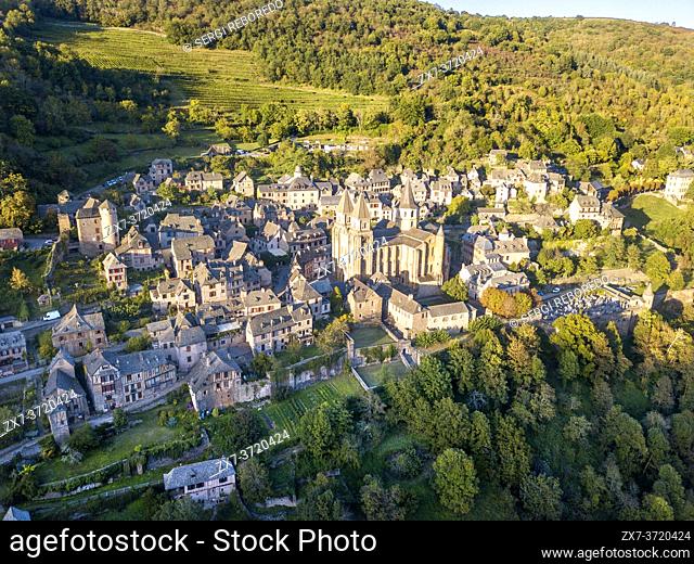 Aerial view of the medieval village of Conques in France. It shows visitors its abbey-church and clustered houses topped by slate roofs