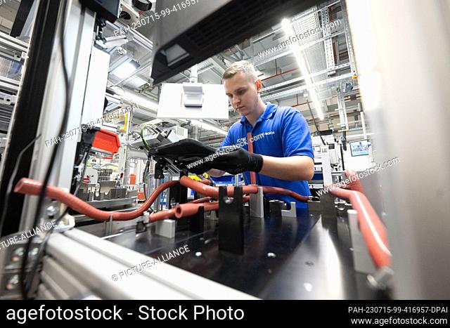 PRODUCTION - 12 July 2023, Baden-Württemberg, Stuttgart: A Robert Bosch GmbH employee checks hose clamps for a fuel cell drive system for generating electricity...