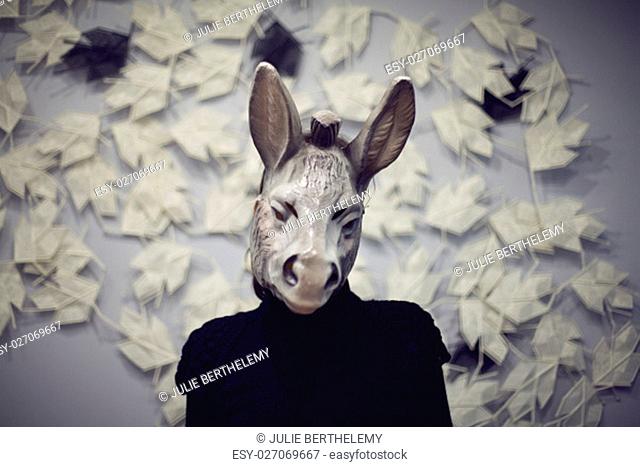 A woman wearing a donkey mask doing a selfie.Blured color photography