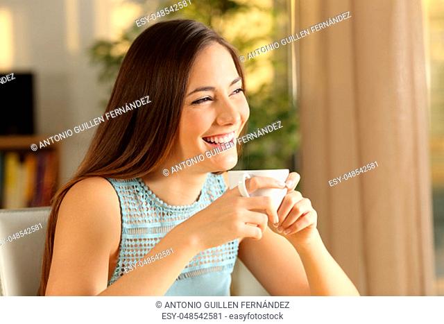 Happy thoughtful girl relaxing and drinking coffee