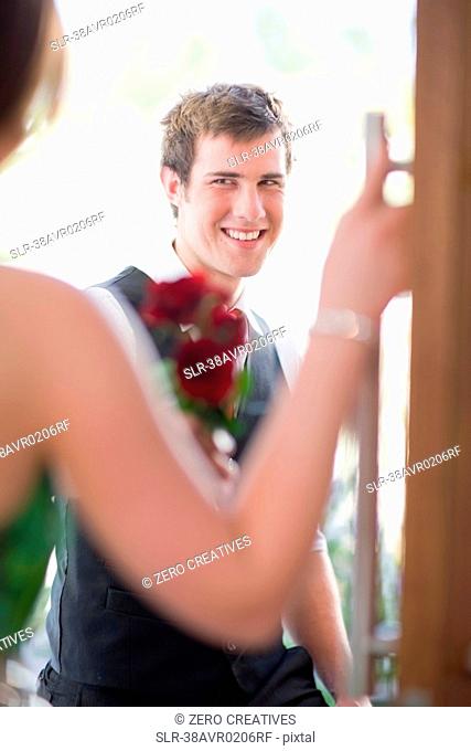 Teenage boy bringing flowers to date