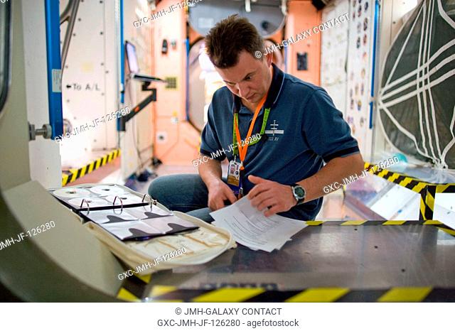 Cosmonaut Roman Romanenko, Expedition 2021 flight engineer, studies checklists during a training session in an International Space Station mock-uptrainer in the...