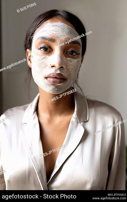 Woman with beauty mask on face waiting to dry at home