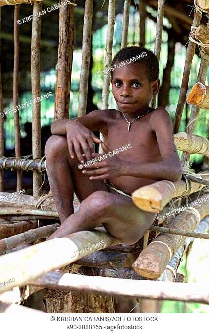 Kombai sitting in front of a wooden house, Papua, Indonesia, Southeast Asia