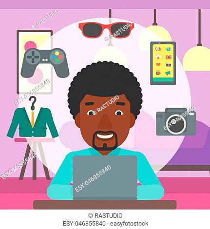 An african-american man sitting in front of laptop and some images of goods around him. Man doing online shopping. Man buying on internet